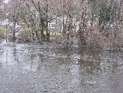 Photograph of the Sudbury River flooding a house on Stonebridge Road in Wayland, MA
