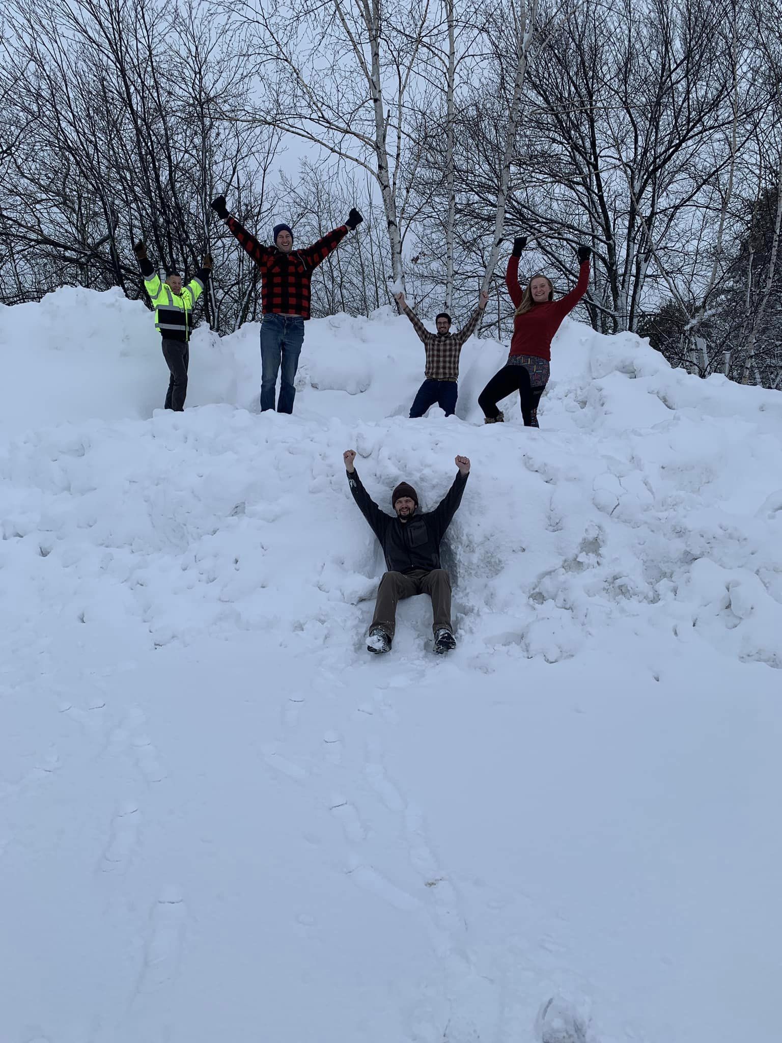 Group Photo- 5 people standing on a snowbank