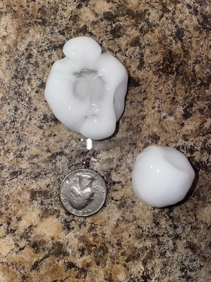 Photo of golf ball size hail in Salem, South Dakota, with a quarter for size comparison.