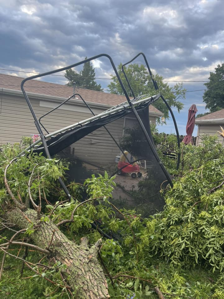 Photo of tree damage and an overturned trampoline in Merrill, Iowa