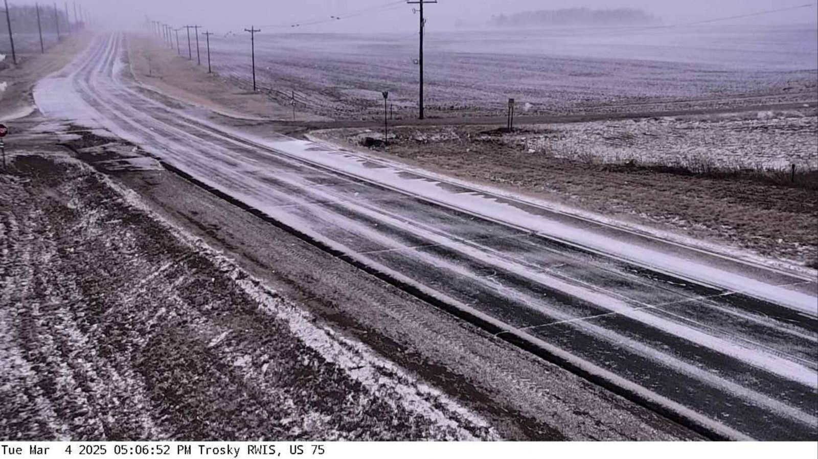 MNDOT webcam photo of icy roads and low visibility due to blowing snow and strong wind gusts near Trotsky, MN at 5:06 PM March 4th.