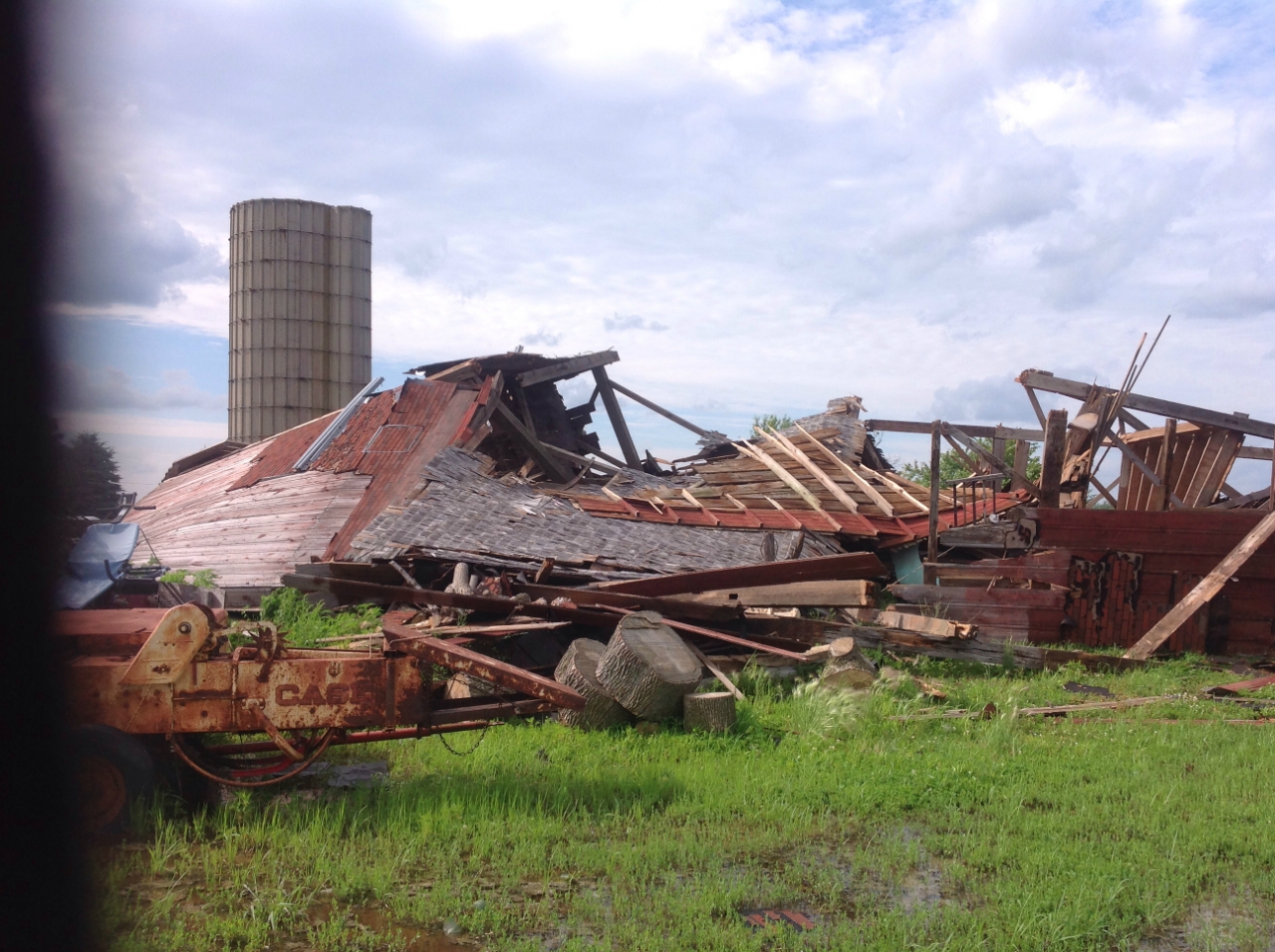 Photo showing damage from a tornado near Grant Park. A farm outbuilding has been completed destroyed with all walls collapsed.