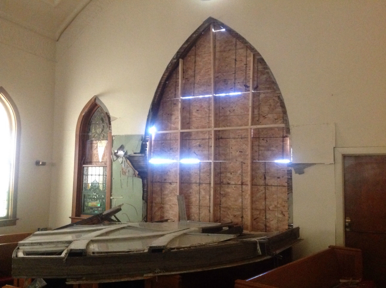 Photo showing damage from a tornado near Grant Park. A large window of a church has been separated from the wall and blown into the interior of the building.