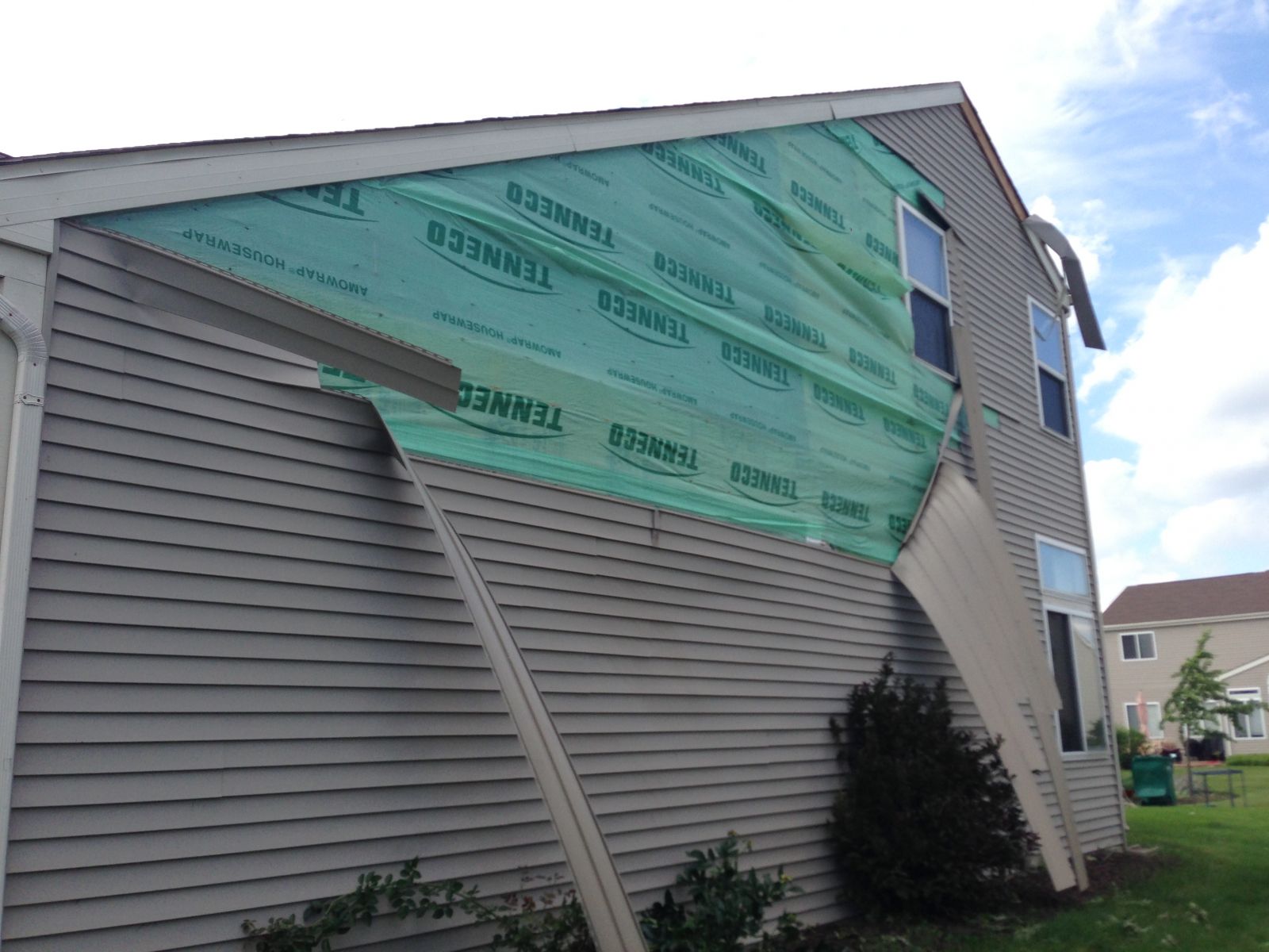 Photo showing damage from a tornado near Plainfield. Pieces of siding have been pulled from a house.